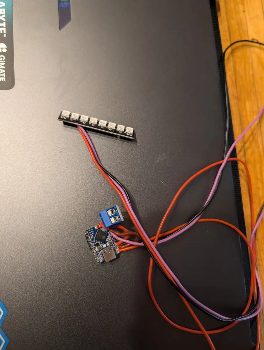 The first prototype on the bench: an 8-LED WS2812B stick wired to an ESP32-S3-Zero with a screw-terminal CAN breakout